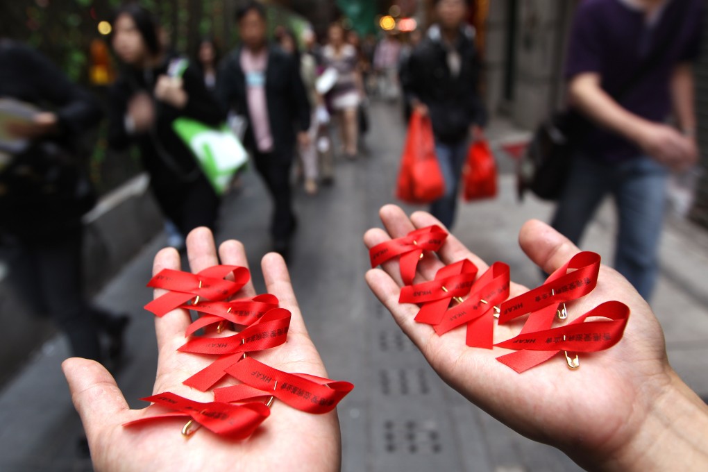 A member of the Hong Kong Aids Foundation holds red ribbons in their hands to commemorate World Aids Day, in Central, on December 1, 2010. Photo: Sam Tsang