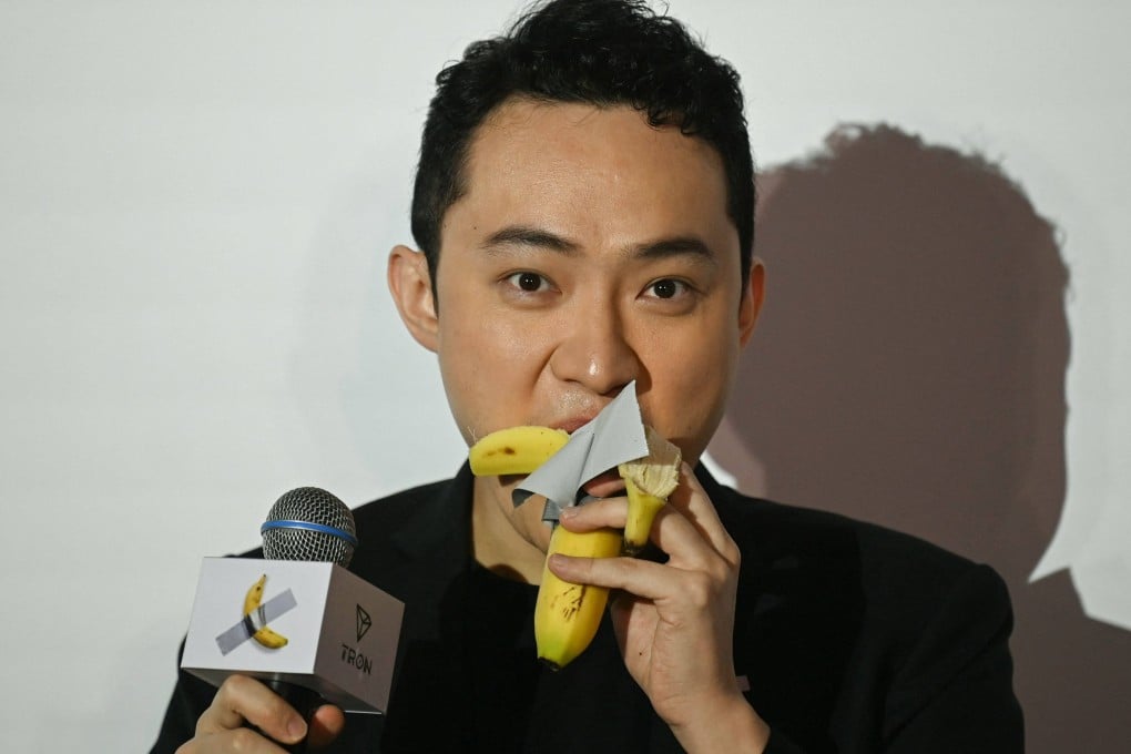 Chinese-born cryptocurrency founder Justin Sun eats a banana artwork, composed of a fresh banana stuck to a wall with duct tape, in Hong Kong on November 29, 2024, a week after buying the provocative work of conceptual art at a New York auction for US$6.2 million. Photo: AFP