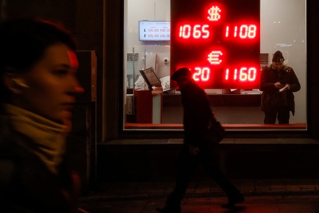 People walk past a board displaying currency exchange rates in Moscow on Wednesday. Photo: Reuters