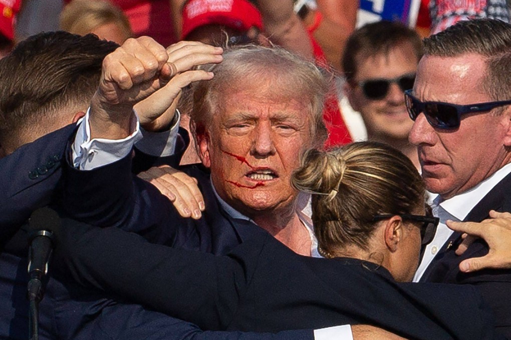 Donald Trump is seen with blood on his face and surrounded by secret service agents after an assassination attempt at a rally in Butler, Pennsylvania, in July. Photo: AFP