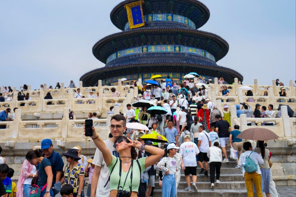 Foreign tourists pose for a photo at the Temple of Heaven in Beijing in July. Photo: Xinhua