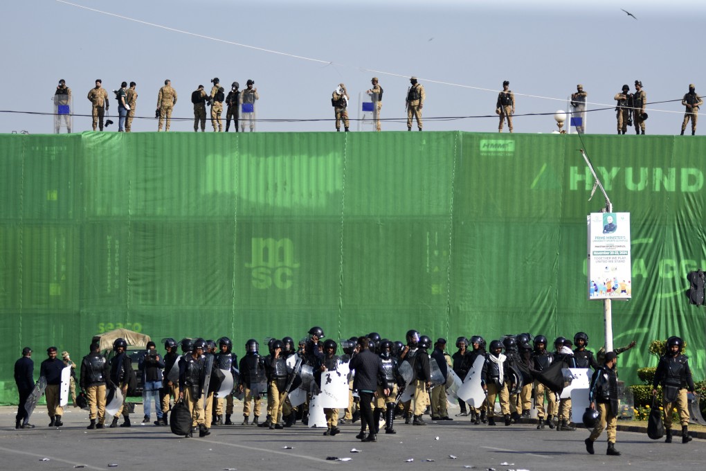 Pakistani troops and police atop a storage container barricade, ahead of a protest by supporters of imprisoned former premier Imran Khan’s Pakistan Tehreek-e-Insaf party, on Tuesday. Photo: AP