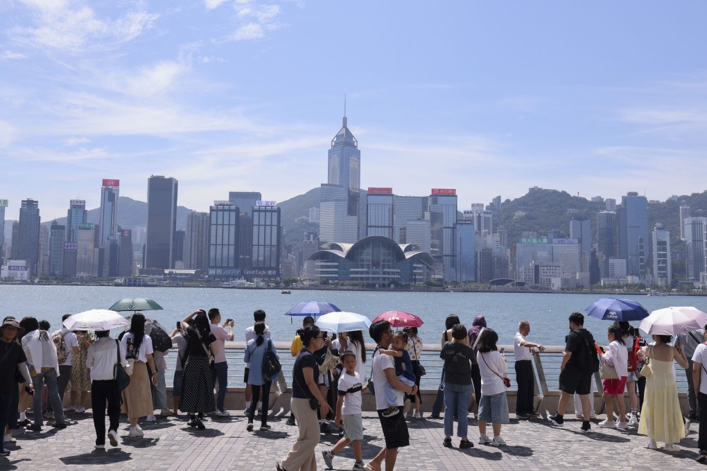 Mainland tourists enjoy the Hong Kong skyline in Tsim Sha Tsui. Photo: Nora Tam