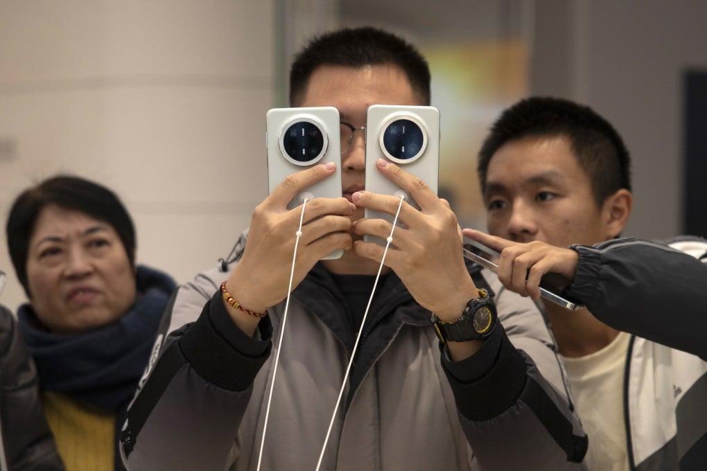 Visitors closely check Huawei Technologies’ new Mate 70-series smartphones at a store in Beijing on November 26, 2024. Photo: EPA-EFE
