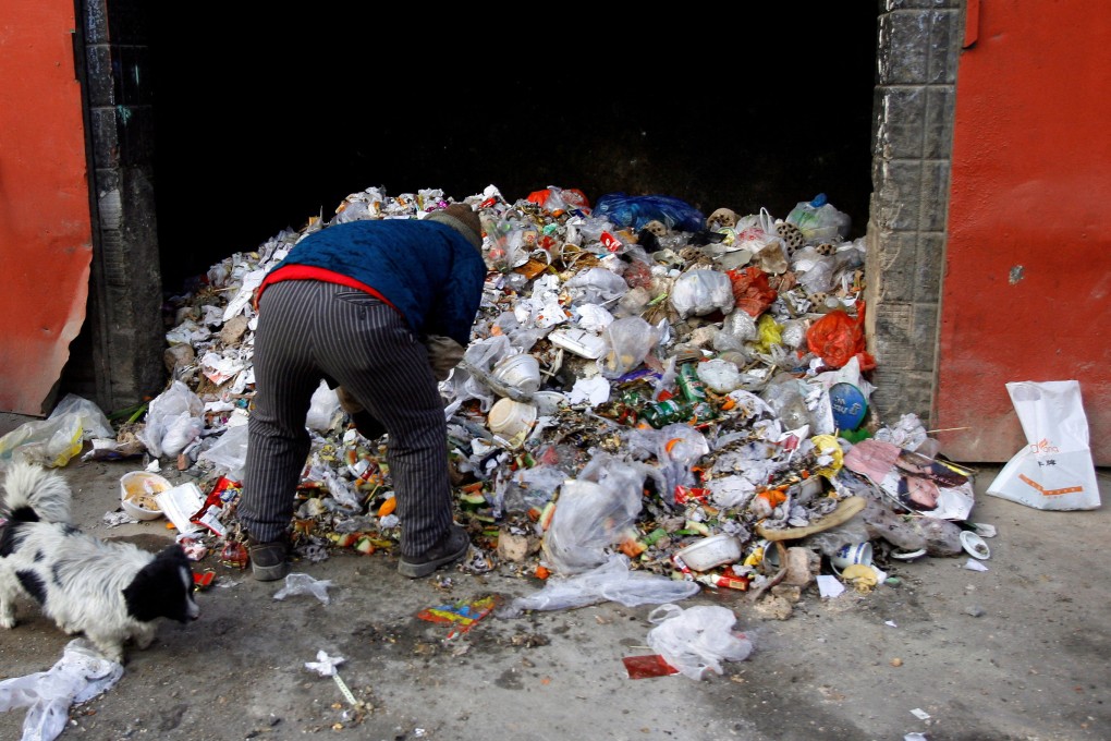 A woman looks through a pile of plastic bags dumped in a Beijing ‘hutong’ street. File photo: Reuters