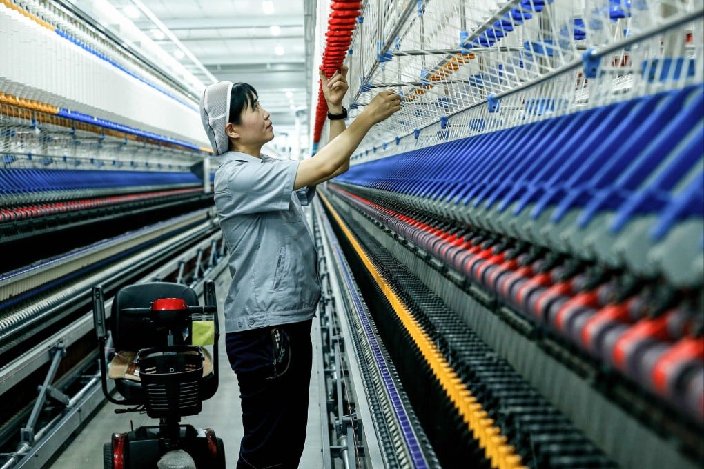 An employee works on a synthetic fiber production line at a textile factory in Qingdao, in China’s eastern Shandong province. Photo: AFP