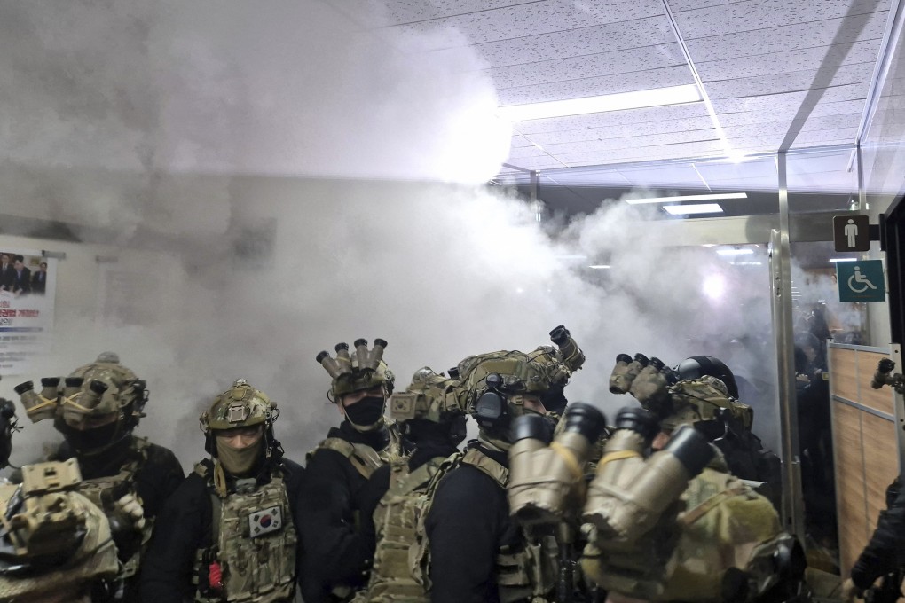 A staff member activates a fire extinguisher to stop soldiers from entering the main hall of the National Assembly in Seoul on Wednesday. Photo: Yonhap via AP