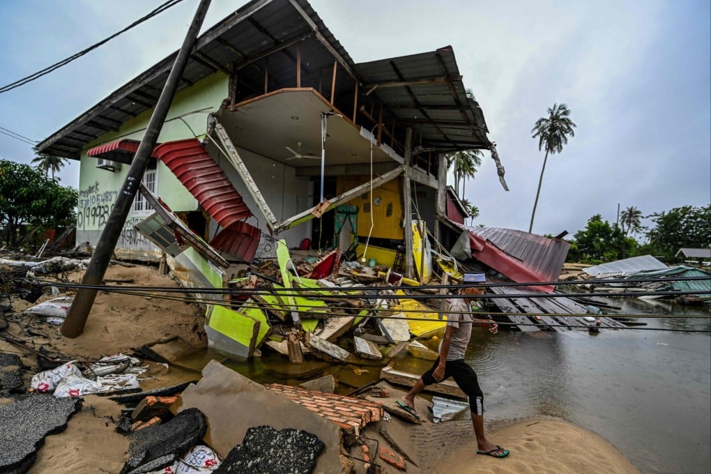 A man walks past a home damaged by floodwaters in Tumpat, Malaysia’s Kelantan state, on Wednesday. Photo: AFP