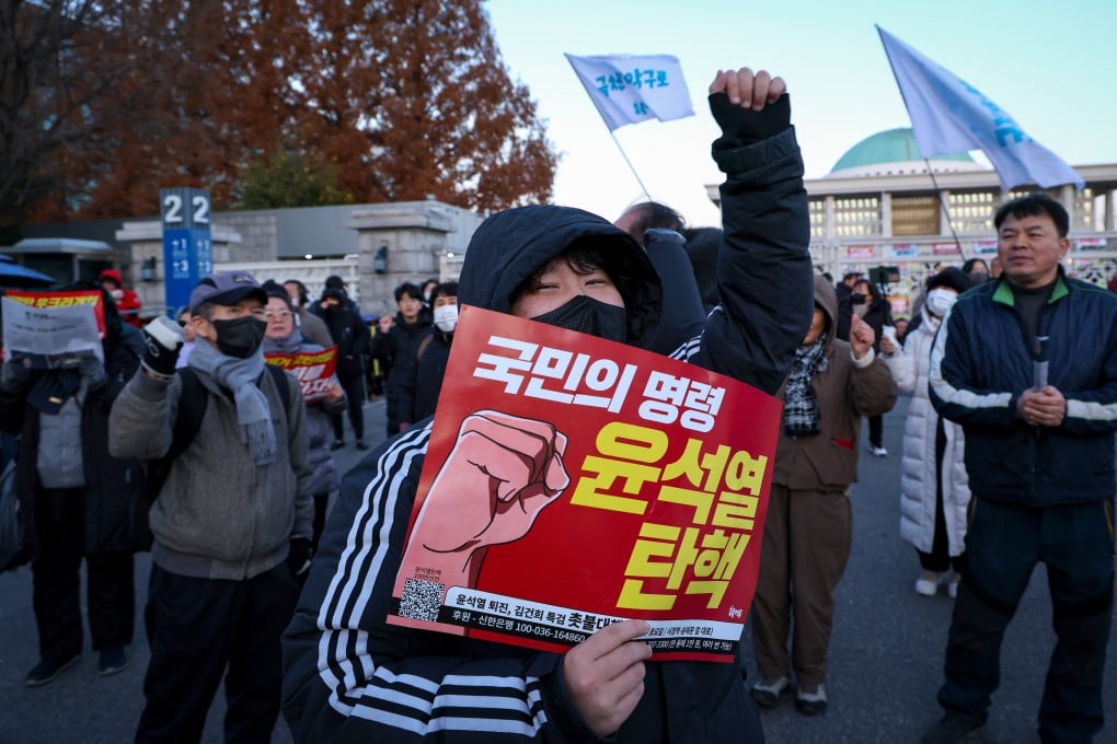 A protester calls for the impeachment and resignation of South Korean President Yoon Suk-yeol outside the National Assembly in Seoul on Wednesday morning after martial law was imposed and withdrawn within hours overnight. Photo: EPA