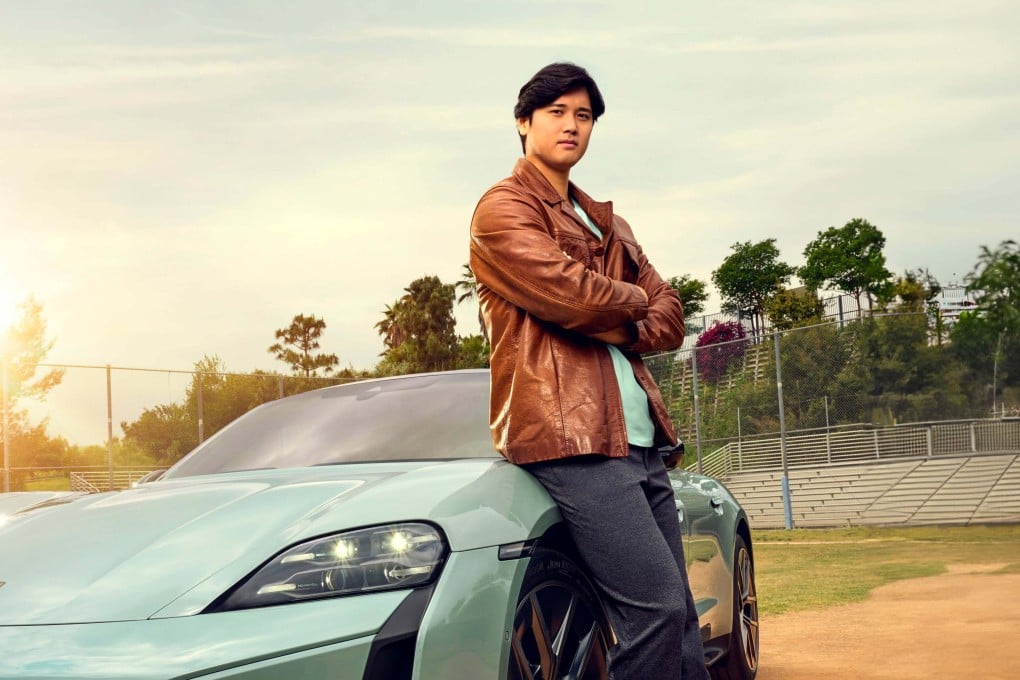 Shohei Ohtani with his 2024 Porsche Taycan Turbo S. The Japanese star had given teammate Joe Kelly a new Porsche when Kelly agreed to hand over his No 17 shirt. Photo: Porsche