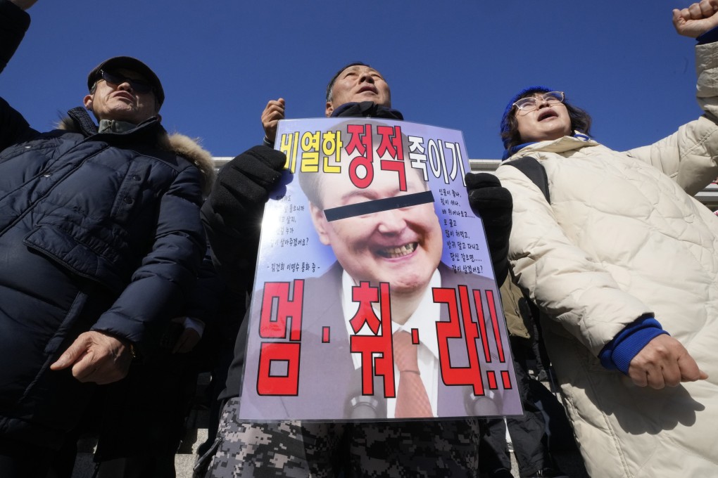 Members of South Korea’s main opposition Democratic Party shout slogans during a rally against President Yoon Suk-yeol at the National Assembly in Seoul, December 4, 2024. The signs read “Stop”. Photo: AP