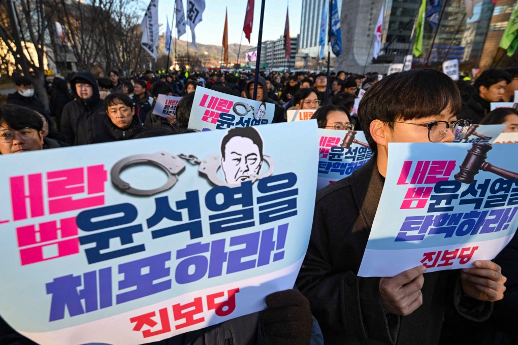 South Korean protesters hold placards reading “arrest treasonous criminal Yoon Suk-yeol!” during a rally against the president. Photo: AFP