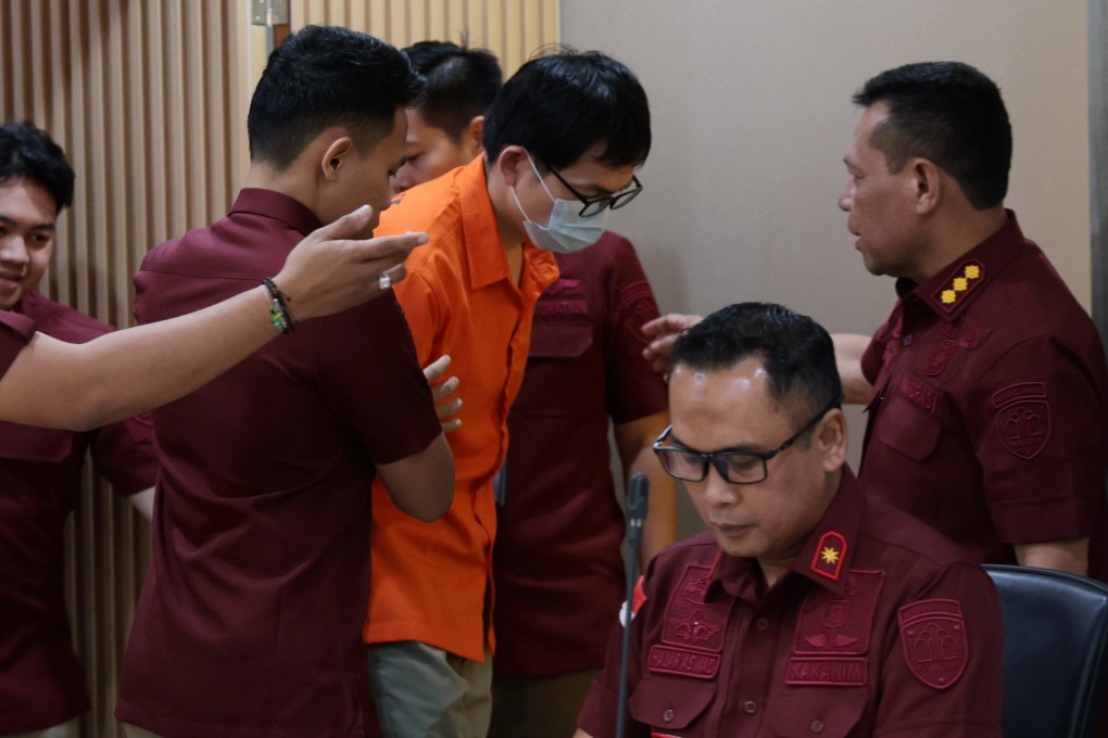 Indonesian immigration officials hold Yan Zhangxing, who was detained on Monday by immigration officers at a cross-border ferry terminal on Batam island, next to Singapore. Photo: EPA-EFE