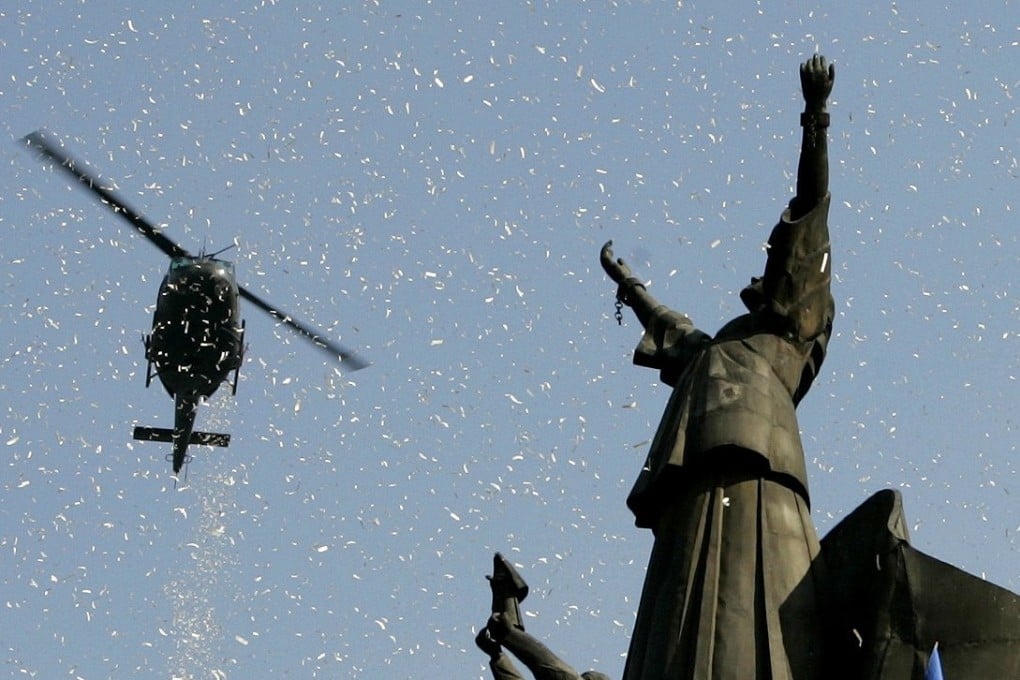 A helicopter releases confetti over the People Power monument during the 21st anniversary celebration of the 1986 People Power Revolution in Manila in 2007. Photo: Reuters