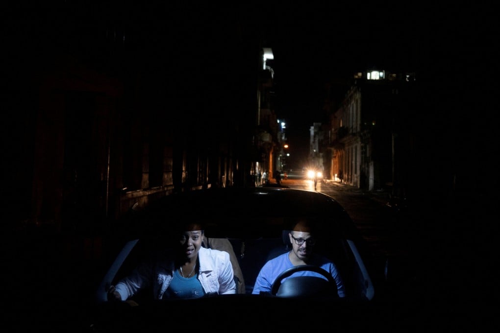 A couple inside a car during an electrical grid collapse, in Havana, Cuba. Photo: Reuters