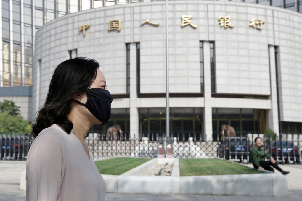 A woman walks past the headquarters of the People’s Bank of China in Beijing. Photo: Reuters
