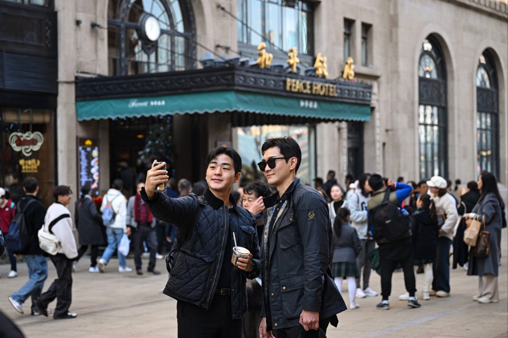 Tourists pose for selfies in front of the Peace Hotel in Shanghai. The number of foreign visitors flocking to China is starting to resemble pre-pandemic levels. Photo: Xinhua