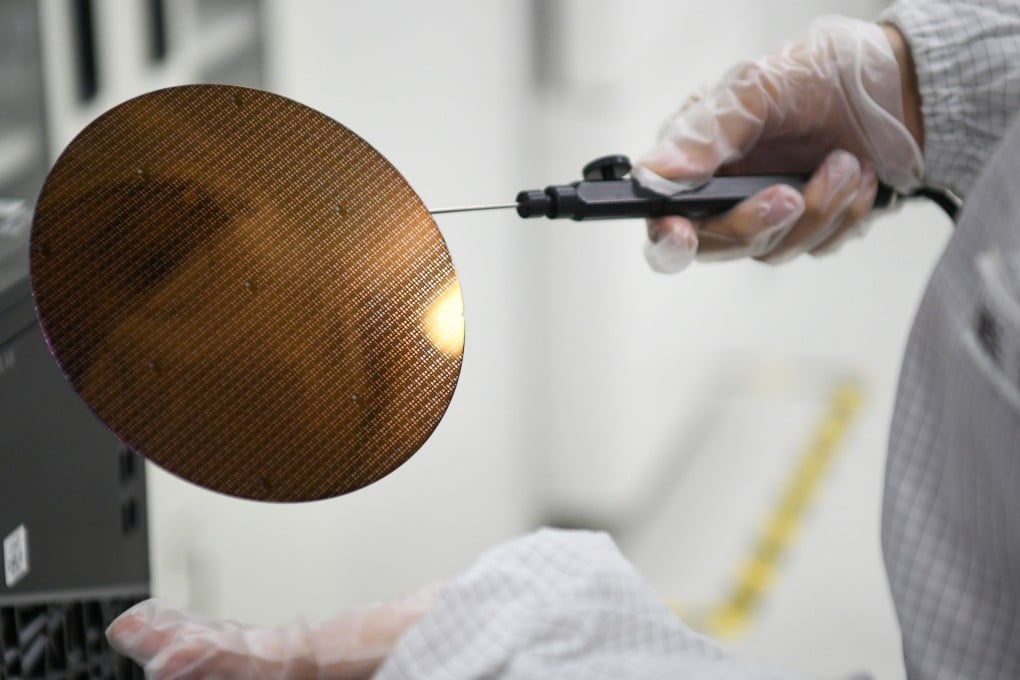 A researcher displays a wafer at Shaanxi Institute of Advanced OEIC Technologies, in Xi’an on March 4, 2024. Photo: Xinhua