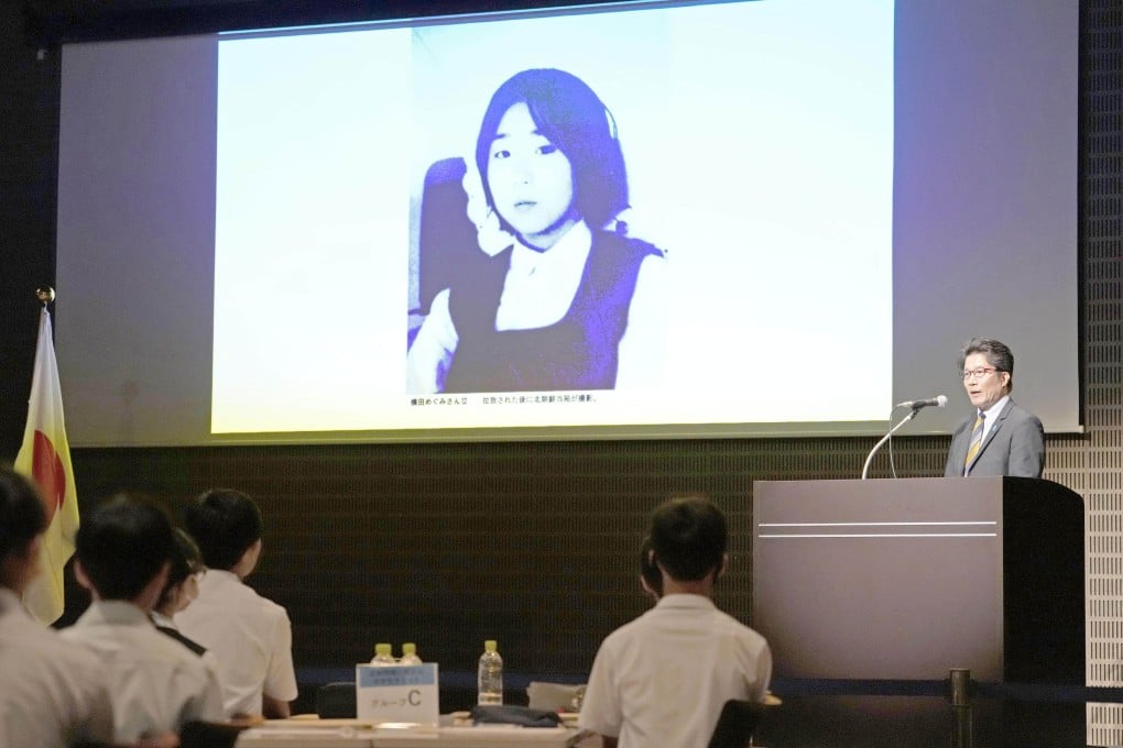 Takuya Yokota, head of a group representing the families of Japanese nationals abducted by North Korea, speaks about the issue in August. His sister Megumi (on the screen) was abducted by North Korea in 1977. Photo: Kyodo