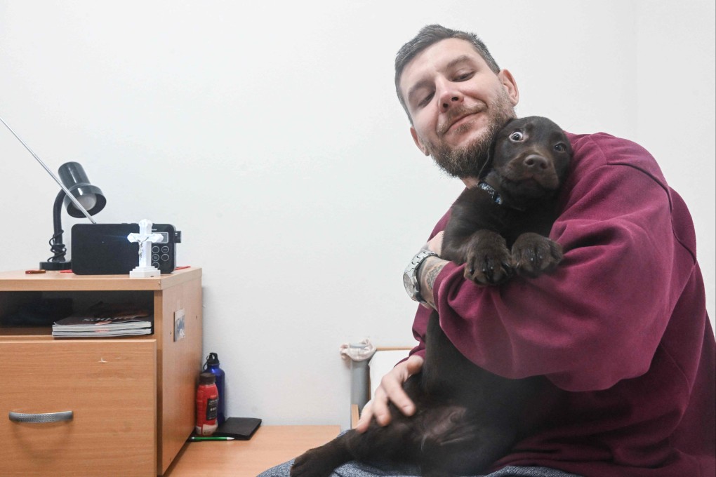 Prisoner Marek Kolar poses for a photo withpuppy named Zirkon. Photo: AFP