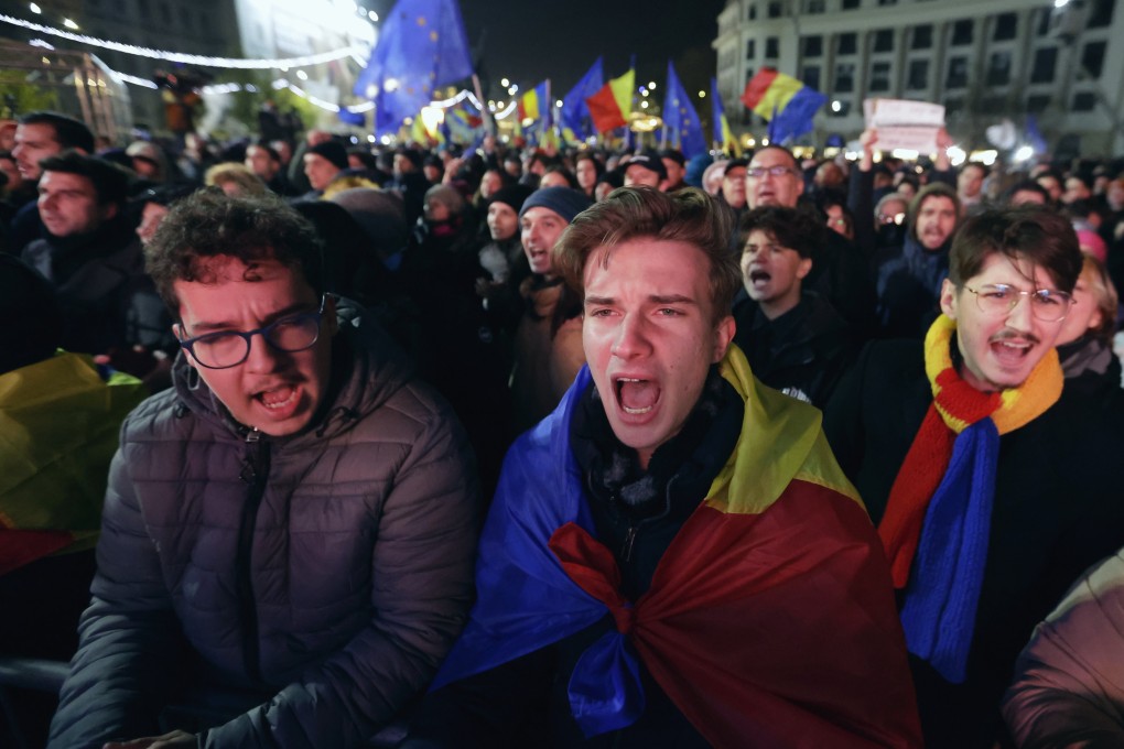 People sing while waving Romanian and European Union flags during a pro-Europe rally ahead of the runoff elections, in downtown Bucharest. Photo: EPA-EFE