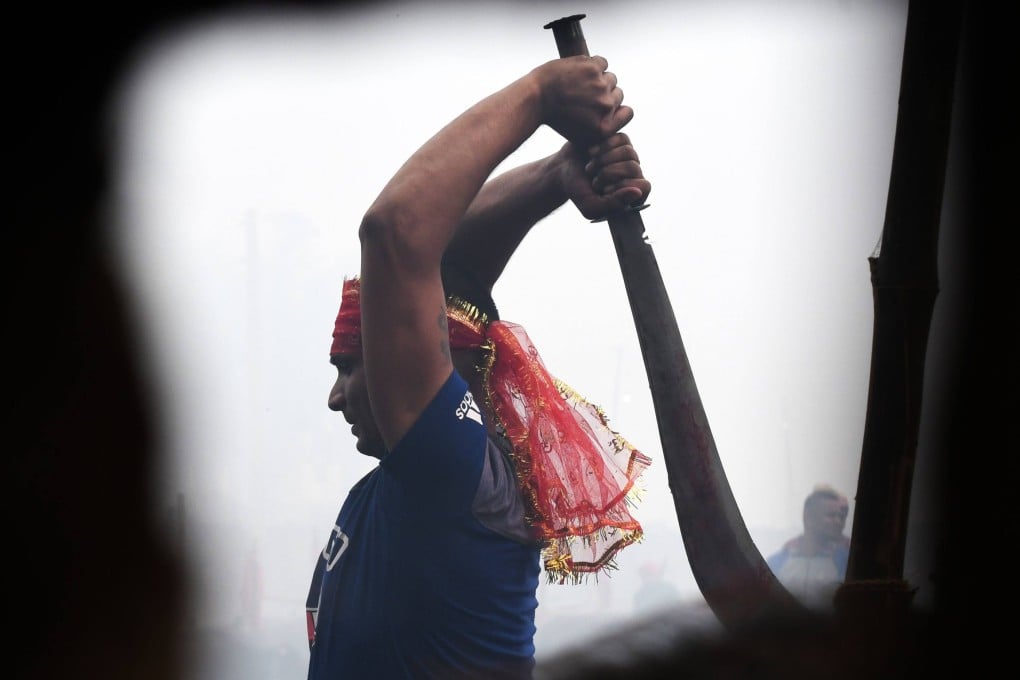 A Hindu devotee prepares to slaughter buffalos as a offering during the 2019 Gadhimai Festival in Bariyarpur, Nepal. Photo: AFP