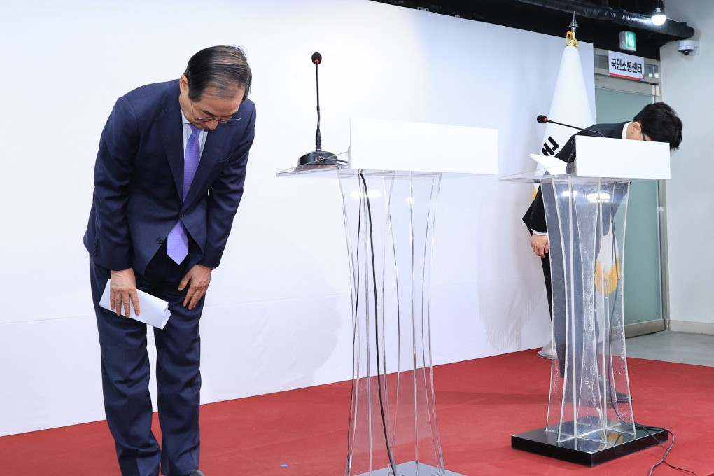 South Korea’s Prime Minister Han Duck-soo (left) and the ruling People Power Party leader Han Dong-hoon (right) bow during a press conference after their meeting to discuss plans for President Yoonl’s “orderly retreat”. Photo: AFP