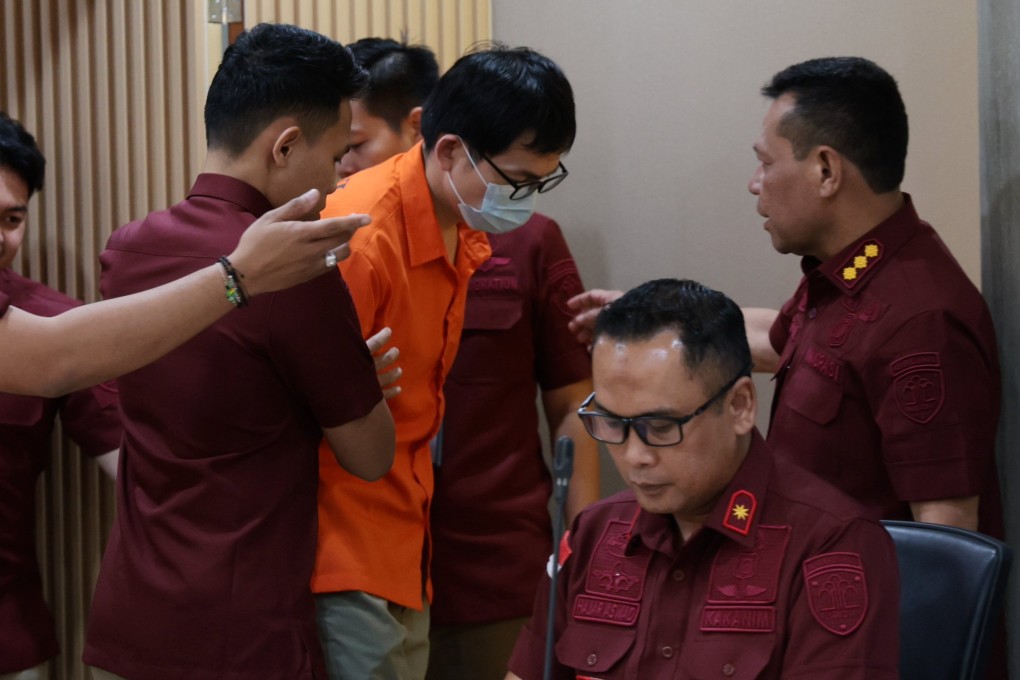 Indonesia immigration officials hold Chinese fugitive Yan Zhangxing (centre). Photo: EPA-EFE