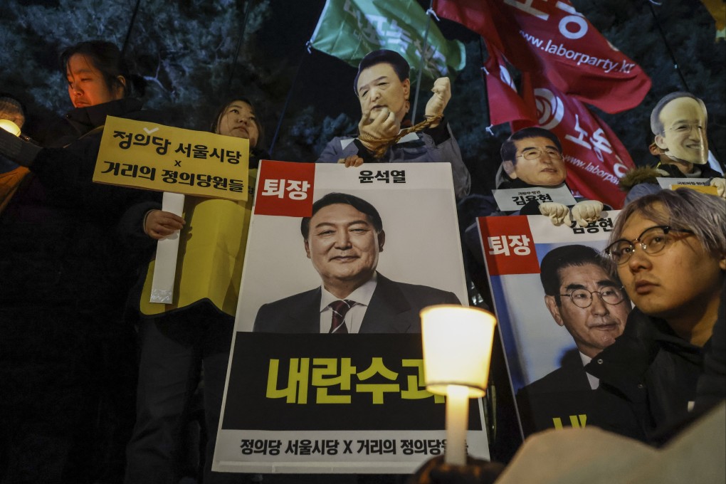 Protesters hold candles and placards calling for the arrest of President Yoon Suk-yeol, outside the National Assembly in Seoul, South Korea, on December 6. Photo:  EPA-EFE