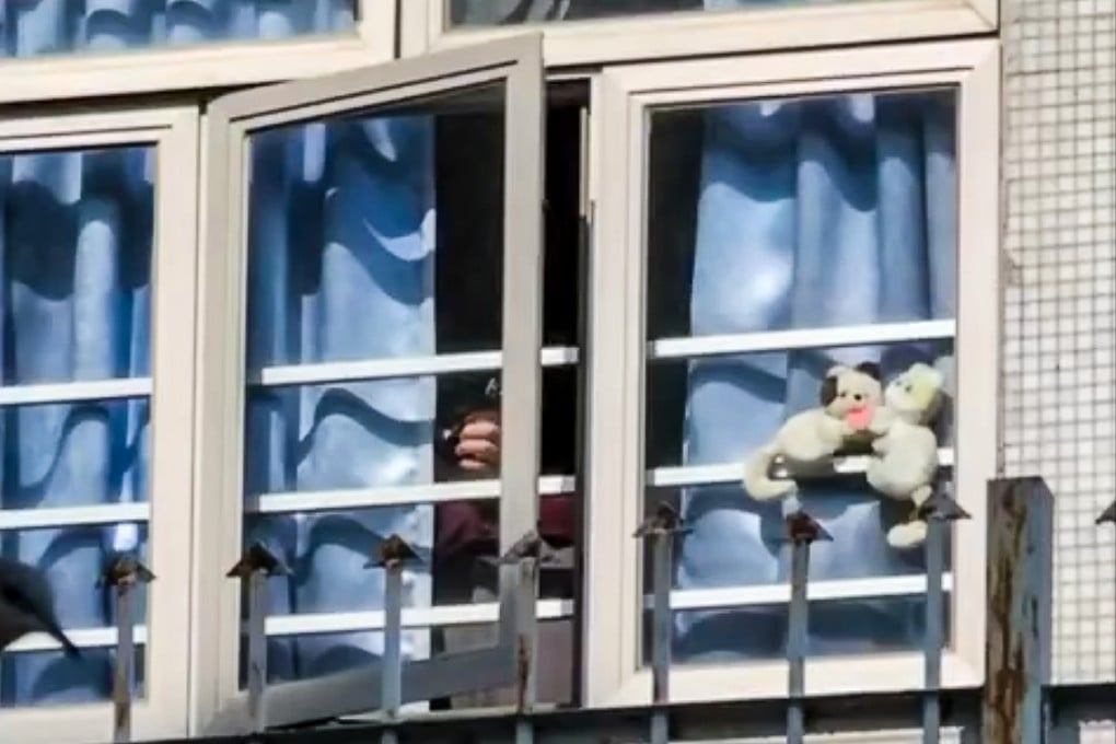 A video posted online shows a man peeking through the curtains of a window of a flat and holding what appears to be an airgun. Photo: Facebook