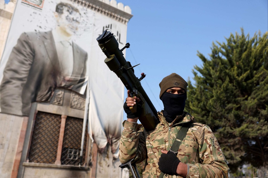 An anti-government near a defaced portrait of Syria’s Bashar al-Assad, in the city of Hama. Photo: AFP