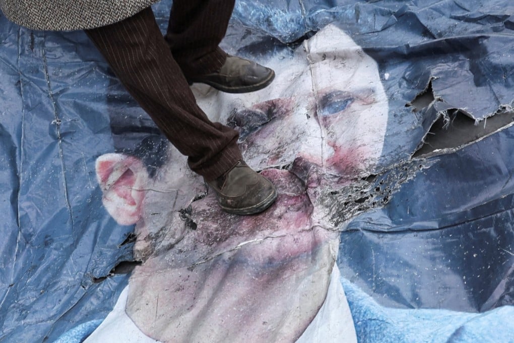 A man walks on a poster of Bashar al-Assad in downtown Damascus, Syria. Photo: Reuters