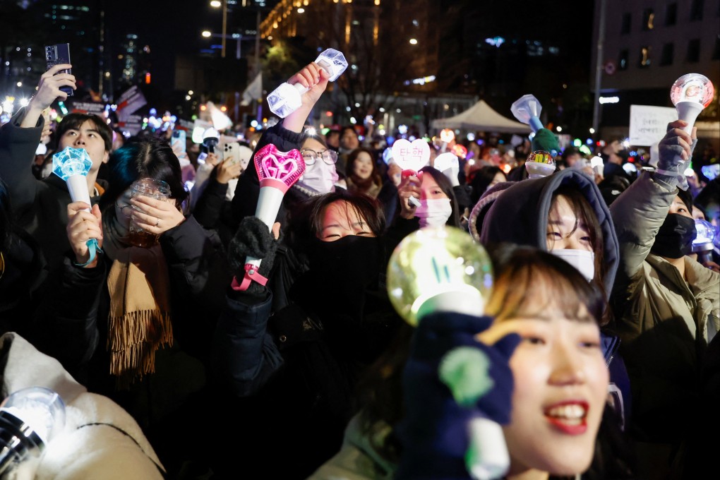 People carry K-pop idol sticks, as protesters take part in a rally on Sunday calling for the impeachment of South Korean President Yoon Suk-yeol. Photo: Reuters
