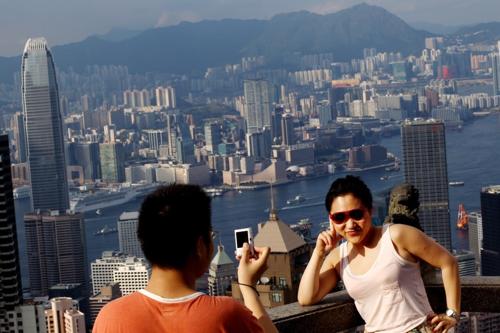 Tourist take photos with the Kowloon skyline and Victoria Harbour from The Peak. Photo: SCMP