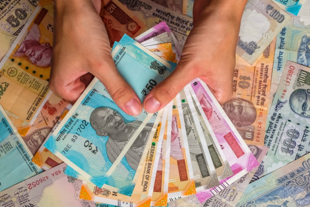 A person holding Indian rupees of different denominations. The wealth of Indian billionaires surged to US$905 billion in 2024, a UBS report shows. Photo: Shutterstock