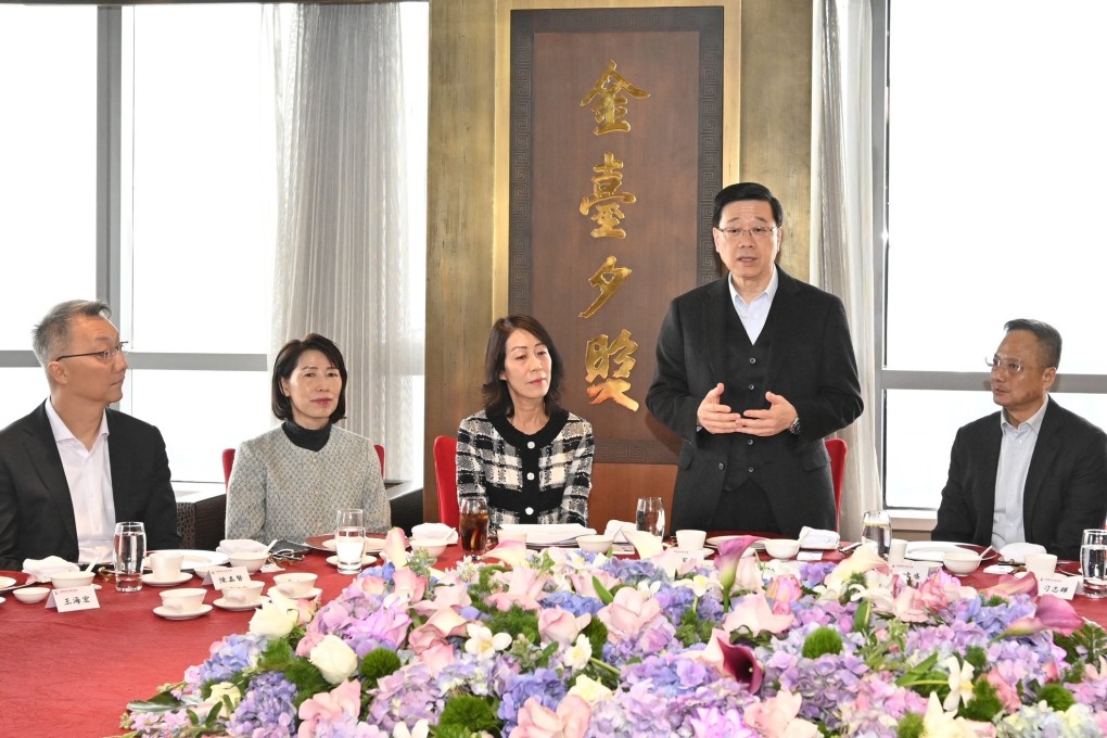 John Lee (standing) meets members of the Hong Kong Chamber of Commerce in China during his visit to Beijing. Photo: Handout