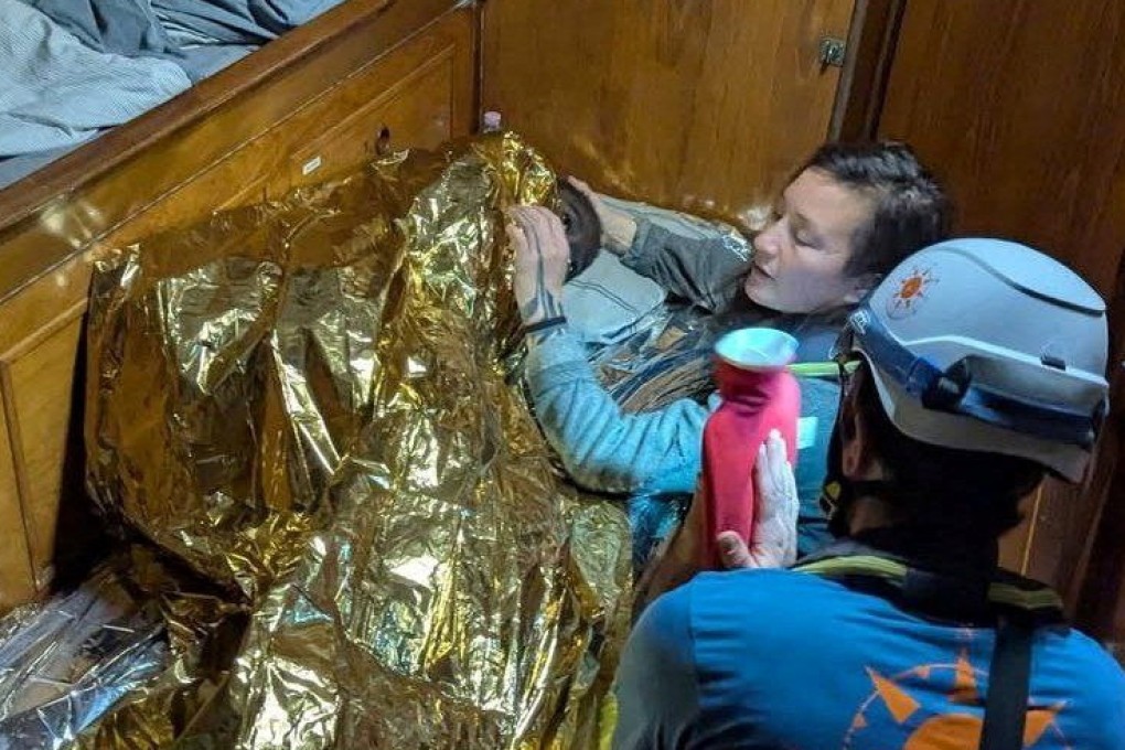 A volunteer assists the girl, the sole survivor of a shipwreck. Photo: Compass Collective via Reuters