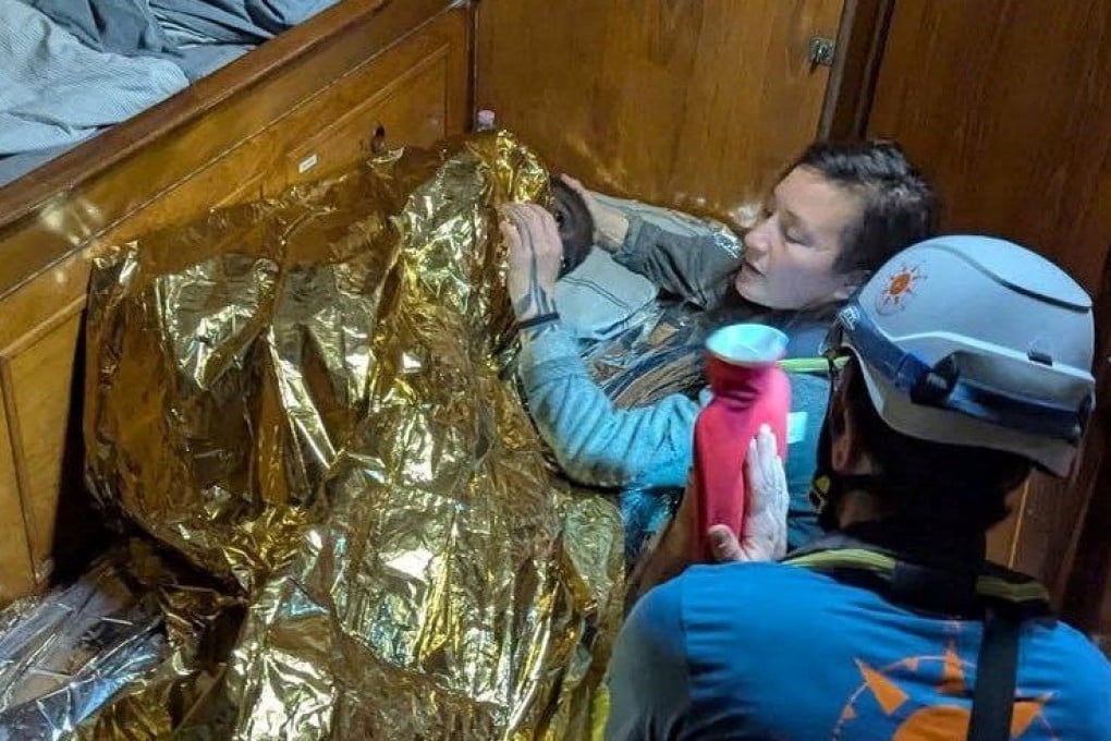 A volunteer assists the girl, the sole survivor of a shipwreck. Photo: Compass Collective via Reuters