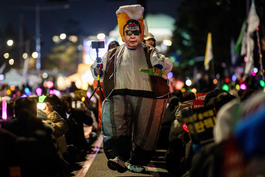 A demonstrator wearing a costume depicting South Korean President Yoon Suk-yeol walks at a protest in Seoul on December 12. Photo: AFP