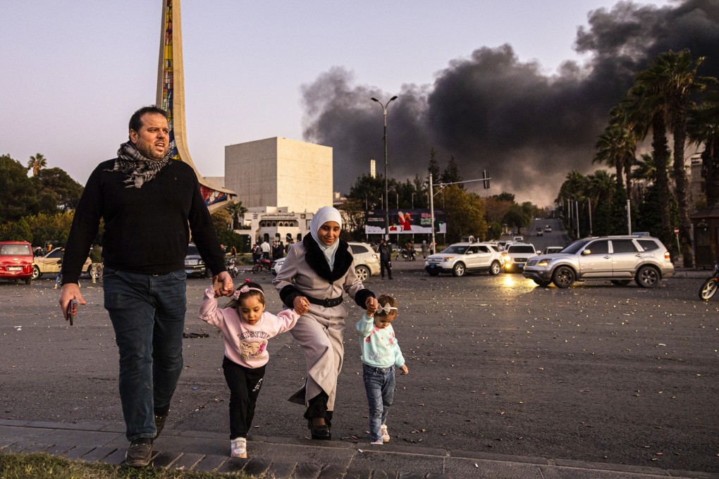 Smoke billows in the distance as people arrive to celebrate the overthrow of Bashar al-Assad, in Damascus, Syria, on December 8. Photo: AP