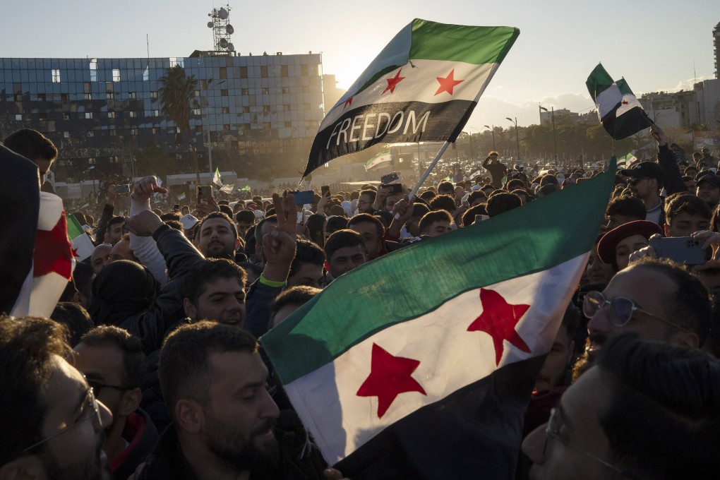 Syrians wave flags during a celebratory demonstration. Photo: AP