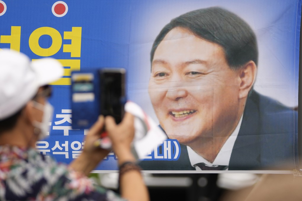 A supporter takes a photo of a banner featuring Yoon Suk-yeol in June 2021, the month he launched his bid to run for South Korea’s presidency. Photo: AP