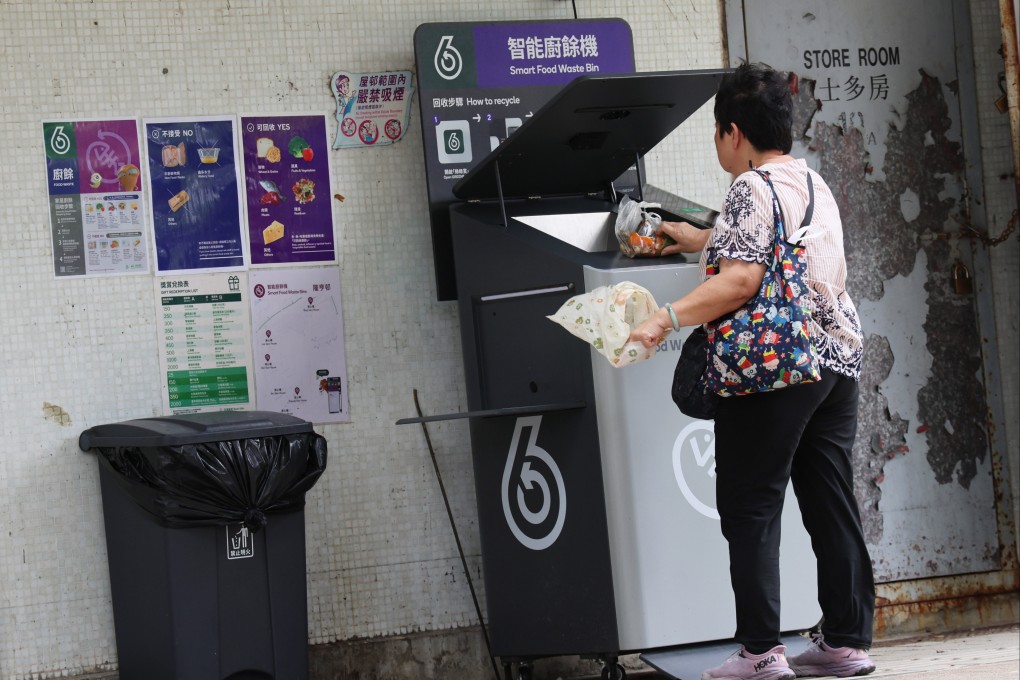 A resident of Lung Hang Estate in Sha Tin places a food waste in a machine for recycling. Photo: Jelly Tse
