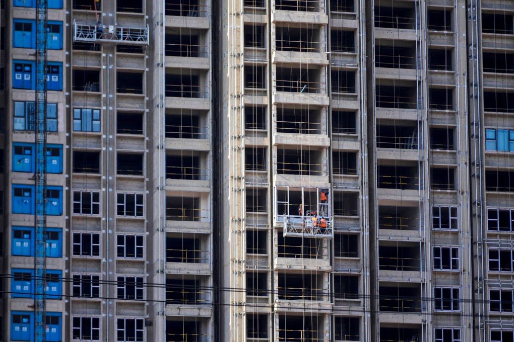 Workers install windows at a residential project in Shanghai. Photo: Reuters