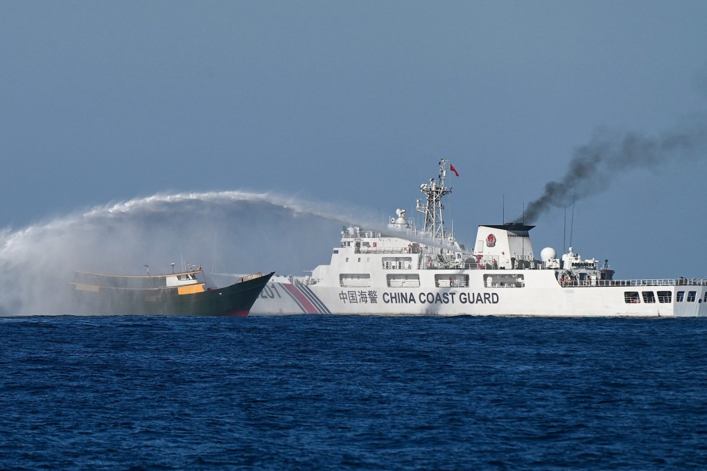 A Chinese coastguard vessel, right, fires a water cannon on a Philippine fisheing vessel near a disputed shoal in the South China Sea on March 5. Photo: AFP