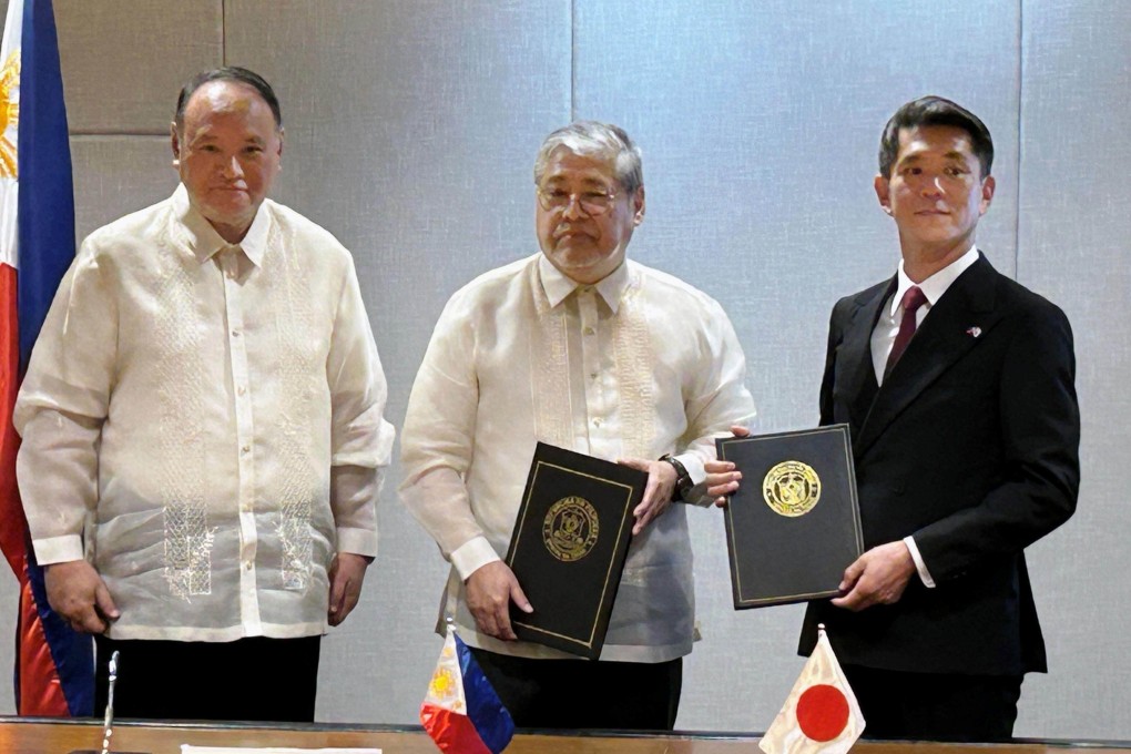 Philippine Defense Secretary Gilberto Teodoro (left) and Foreign Secretary Enrique Manalo (centre) pose with Japanese Ambassador to the Philippines Kazuya Endo in Manila on December 5, after the countries signed an agreement for Japan to provide coastal surveillance radar to Manila. Photo: Kyodo