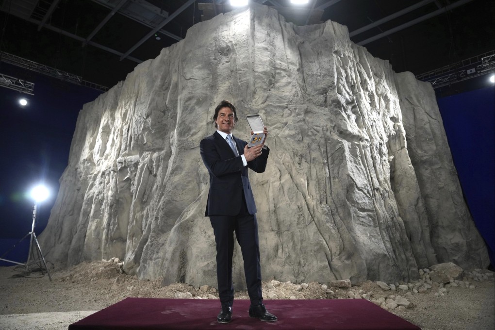 Tom Cruise poses with the US Navy’s Distinguished Public Service Award in Surrey, England, on Tuesday. Photo: AP