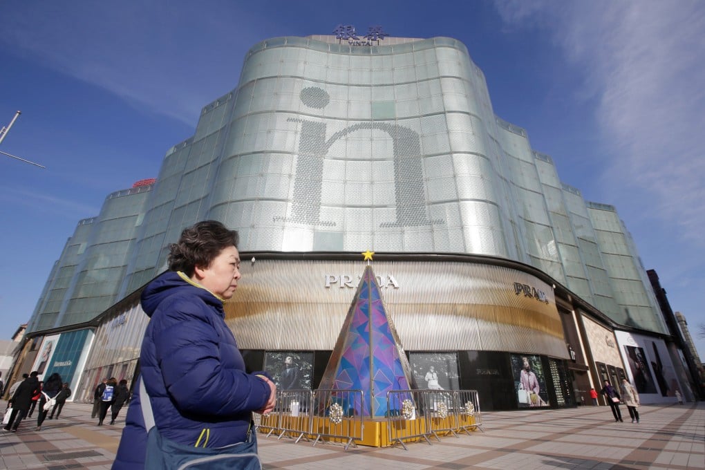 A woman walks past an Intime Lotte shopping centre in downtown Beijing on January 10, 2017. Photo: Reuters