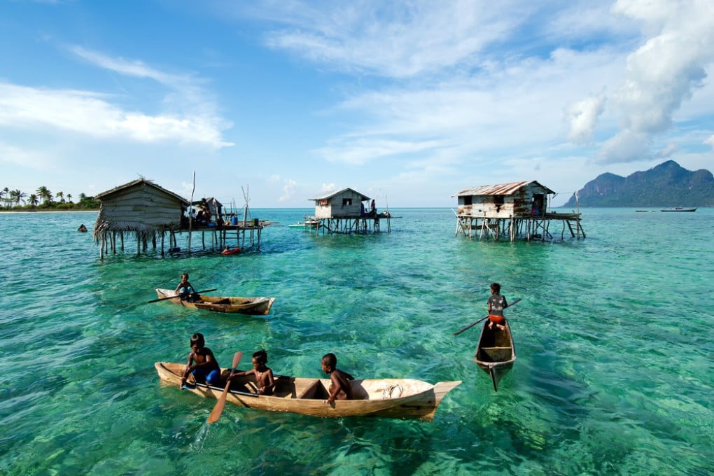 Young Bajau Laut children paddling a boat near stilted houses off the coast of Borneo near Tun Sakaran Marine Park. Photo: Shutterstock