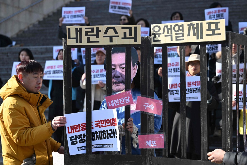 A protester wearing a mask of impeached South Korea President Yoon Suk-yeol performs in a mock prison during a demonstration calling for Yoon’s ouster in Seoul on December 19. Photo: AFP
